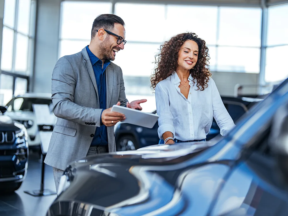 Salesperson with a customer at a car dealership