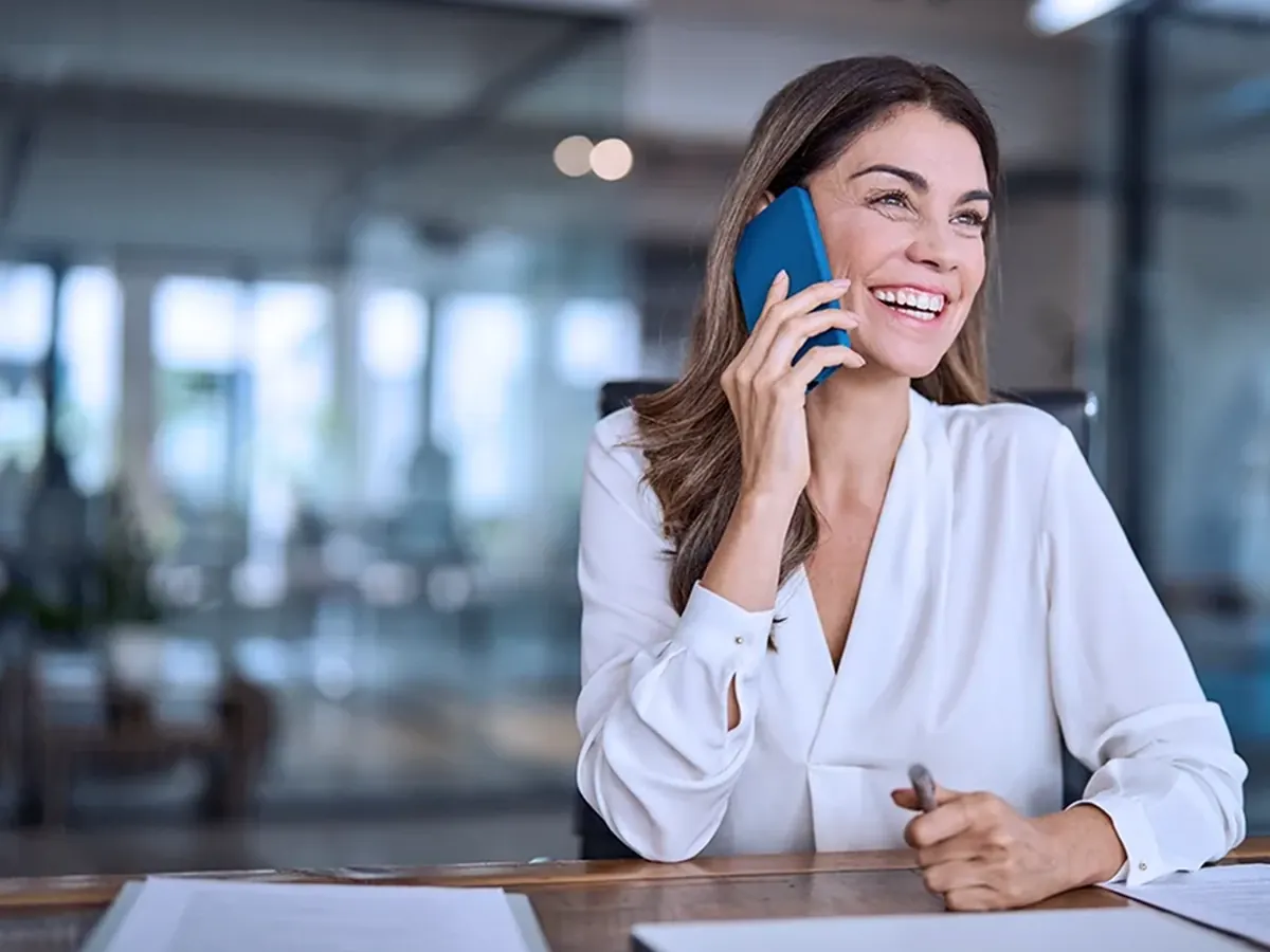 Insurance professional taking a call at her desk in a corporate office